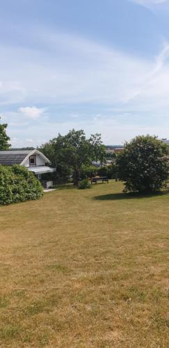 a field of grass with a house in the background at Vita Lilla Stugan i Vimmerby in Vimmerby