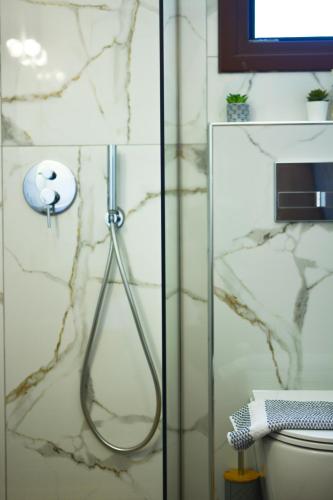 a shower in a bathroom with a glass door at Aura Skiathos in Skiathos Town