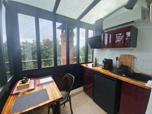 - une cuisine avec une table et quelques fenêtres dans l'établissement Le Cocon Troglodyte, à Saint-Étienne-de-Chigny