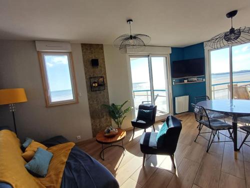 un salon avec un canapé, une table et des chaises dans l'établissement Appartement LES PIEDS DANS L'EAU, à Saint-Gilles-Croix-de-Vie