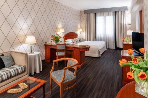 ein Hotelzimmer mit einem Bett und einem Wohnzimmer in der Unterkunft Starhotels Majestic in Turin