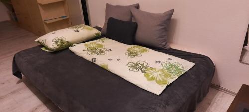 a bed with two pillows on top of it at Wohlfühl-Appartement in Maierhöfen