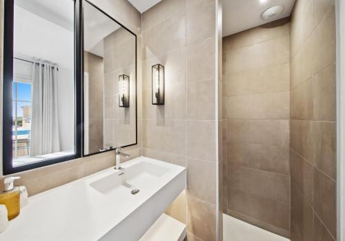 a bathroom with a sink and a mirror at Hôtel La Nartelle in Sainte-Maxime