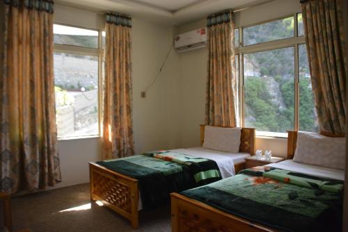 a bedroom with two beds and a window at Besham Inn, Besham in Besham