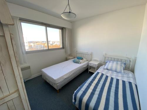 1 dormitorio con 2 camas y ventana en Bel Appartement face mer - GARAGE, en Les Sables-dʼOlonne