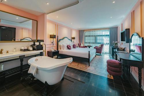 a bedroom with a bed and a bath tub and a sink at The Now boutique Hotel & Apartment in Da Nang