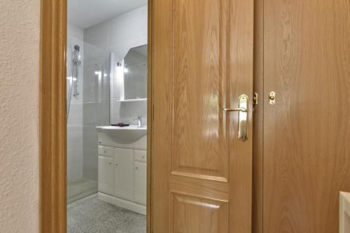a bathroom with a sink and a wooden door at Apartment Sunset Moraira City in Moraira