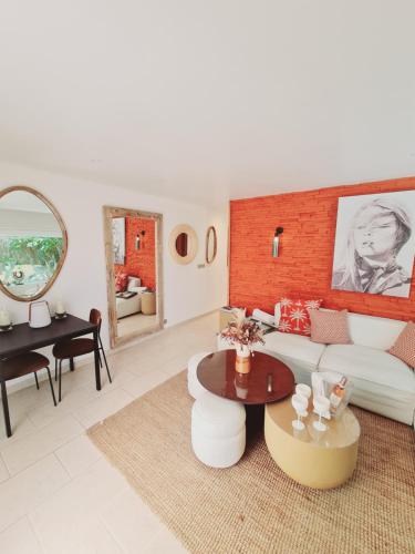 un soggiorno con divano bianco e tavolo di Appartement luxueux à 100m de la plage a Saint-Tropez
