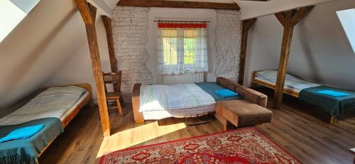 a attic bedroom with two beds and a window at Oliwkowe Jerzykowo -klimatyzacja in Radzieje
