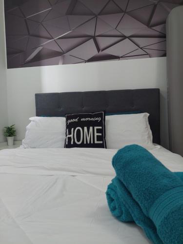 a bedroom with a bed with a blue towel on it at KLIA Travel Homestay - 3R 2B - WIFI & NETFLIX in Sepang