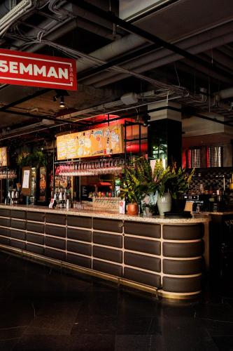 a restaurant with a bar with plants at Hobo Hotel Stockholm in Stockholm