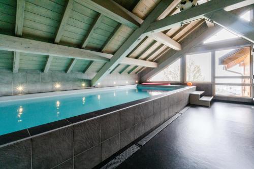 une piscine dans un immeuble avec une grande fenêtre dans l'établissement Chalet le jardin d'hiver, à La Toussuire
