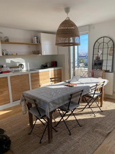 une cuisine avec une table et des chaises dans une pièce dans l'établissement Magnifique penthouse familial à Saint Ouen - Idéal jeux Olympiques, à Saint-Ouen