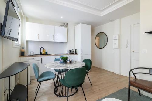 une cuisine avec une table et des chaises dans une pièce dans l'établissement B2#Two Bedrooms#Champs Elysées#Arc de Triomphe#AC, à Paris