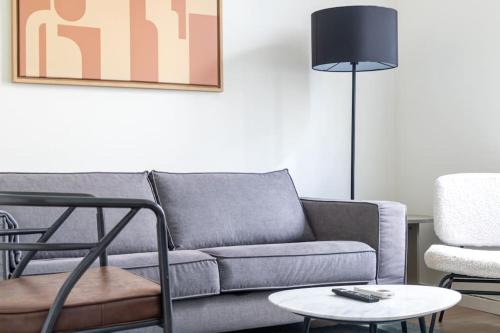 un salon avec un canapé, une table et une lampe dans l'établissement B2#Two Bedrooms#Champs Elysées#Arc de Triomphe#AC, à Paris