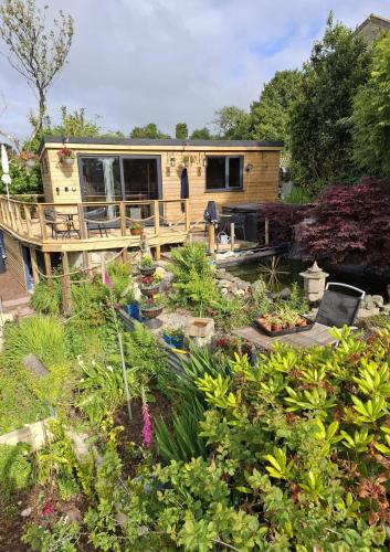 a tiny house in a garden with plants at Cosy Cornish Cabin in St Austell