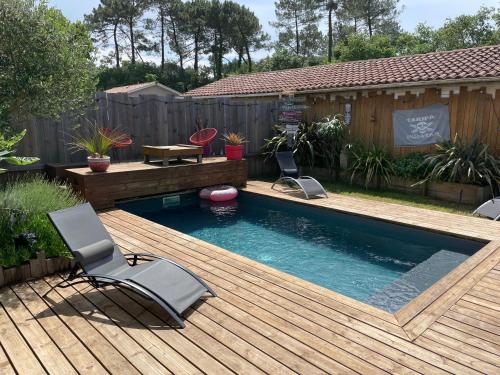 une piscine dans le jardin avec une terrasse, une table et des chaises dans l'établissement Maison 8 personnes avec piscine, à Labenne