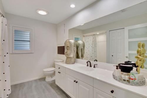 a bathroom with a sink and a toilet and a mirror at Privacy Pool Gulf Access and Luxury in Bonita Springs