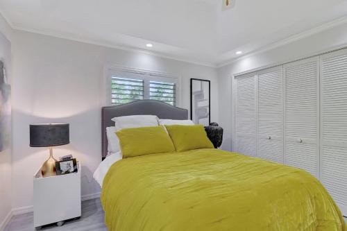 a bedroom with a large bed with a yellow bedspread at Privacy Pool Gulf Access and Luxury in Bonita Springs