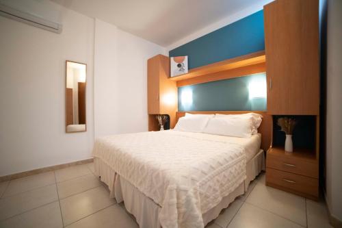 - une chambre avec un lit blanc et un mur bleu dans l'établissement Ferienwohnung ulivo mit Pool und Privatstrand, à Mattinata