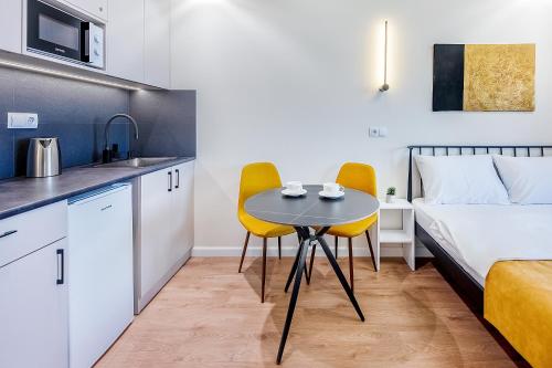 Una pequeña cocina y una mesa en una habitación con una cama. en HB apartments University II, en Tiflis