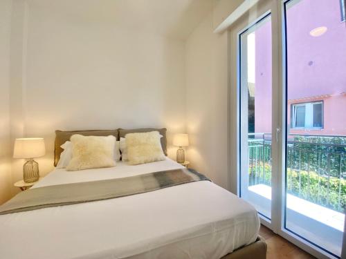 a bedroom with a bed and a large window at CasaViva - Terrace Apt with Parking in Rapallo in Rapallo
