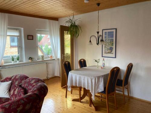 Ferienwohnung Heideweg في شنيفردينغين: غرفة طعام مع طاولة وكراسي