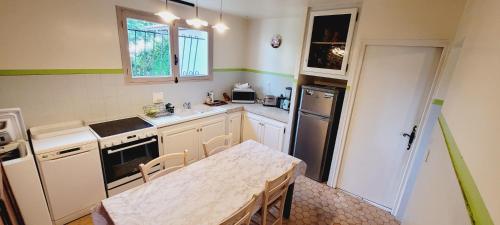 - une cuisine avec une table, un évier et une table dans l'établissement Les Roitelets, à Mimizan-Plage