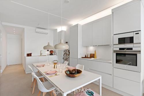 une cuisine blanche avec une table et des chaises blanches dans l'établissement Suite Grand Sud FSHH, à Nice