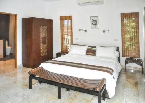 um quarto com uma cama e um banco em 3 bedrooms villa at Tambon Mae Nam 500 m away from the beach with sea view private pool and furnished terrace em Ban Bang Po