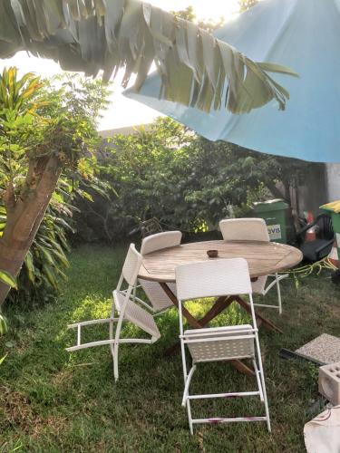 einen Holztisch und Stühle im Hof in der Unterkunft Studio avec jardin clos et wifi a Saint Pierre in Saint-Pierre