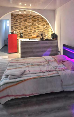 ein großes Bett in einem Zimmer mit Ziegelwand in der Unterkunft Studio avec jardin clos et wifi a Saint Pierre in Saint-Pierre