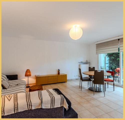 un salon avec un lit et une table dans l'établissement Chez Marta I T3 Avec Jardin I Annemasse, à Annemasse