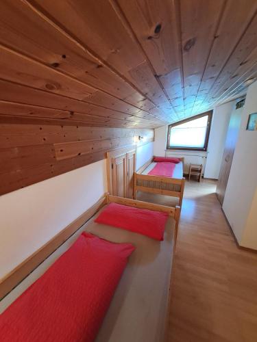 two beds in a small room with wooden walls at Landerhauser-Hof in Schleching