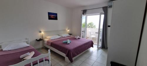 una camera da letto con due letti con lenzuola viola e un balcone di Villa La Playa a Pola (Pula)