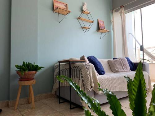 a living room with a couch and a blue wall at Apartamento Xodó - completo - 102 country club Juazeiro in Juazeiro