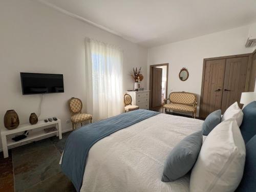 a bedroom with a large bed and a television at Herdade Terra rica in Alcácer do Sal