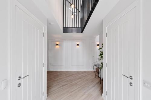 a hallway with white walls and a ceiling with a chandelier at Flour Mill House - Pitkerro Mill in Dundee