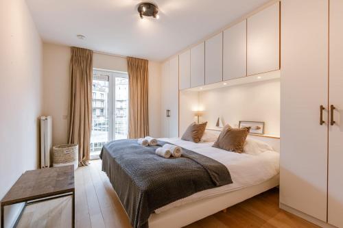 a bedroom with a large bed with two teddy bears on it at Huswell - Apartment on top location in Knokke with parking in Knokke-Heist