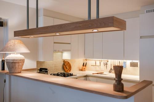 a kitchen with white cabinets and a light fixture at Huswell - Apartment on top location in Knokke with parking in Knokke-Heist