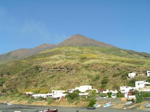 a mountain with a town and houses on it at Villa Mareblu Luxury Holiday Apartment direttamente sul mare in Stromboli