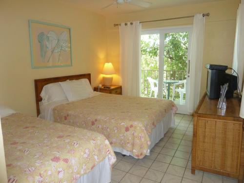 a hotel room with two beds and a balcony at Galleon House Hotel in Charlotte Amalie