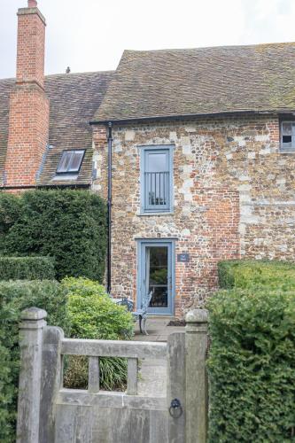 コルチェスターにあるToll Barn, St Osyth Prioryの塀の前のレンガ造りの家