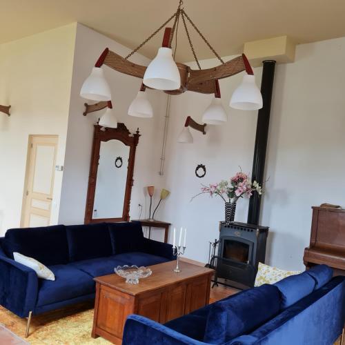 - un salon avec des canapés bleus et une cheminée dans l'établissement Le Théâtre, à Marigny-sur-Yonne