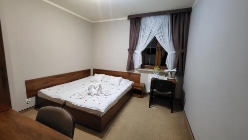 una camera con letto, scrivania e finestra di Hotel Chańcza a Raków