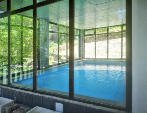 een groot zwembad met uitzicht door een raam bij One bedroom apartement with shared pool sauna and terrace at La Pinilla in La Pinilla