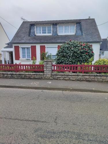 una cerca roja frente a una casa en Studio Madeleine "endroit calme" en Morlaix