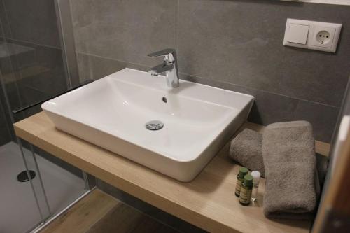 a white sink in a bathroom with a shower at Mesnerwirt in Neukirchen am Teisenberg
