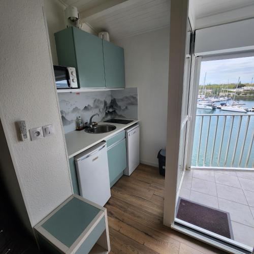 une petite cuisine avec vue sur un bateau dans l'établissement Studio cabine 4 pers vue mer, au Cap d'Agde