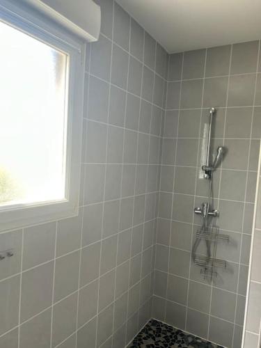 La salle de bains est pourvue d'une douche et d'une fenêtre. dans l'établissement L escapade du Cap, à Barneville-Carteret